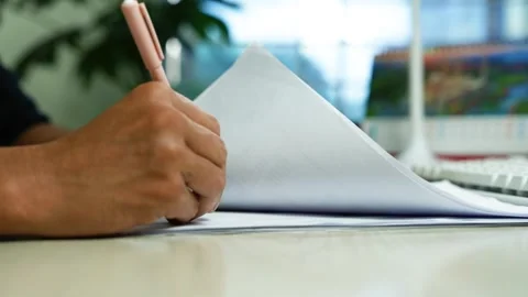 Person writing notes in a notebook at office desk, Close-up of a person wri.. Stock Footage 345119973