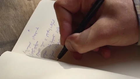 Person writing with a pen Georgian script on a notebook - High angle Close Stock Footage 146742724