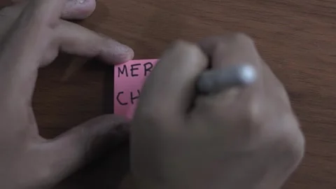 A person is writing on a sticky note on a table wood background. the person.. Stock Footage 287045045