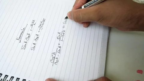 Person writing trigonometric formulas in a notebook with a pen Stock Footage 318057212