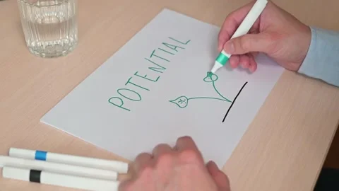 A person is writing the word potential while drawing a simple plant design using Stockbeeldmateriaal 337558608