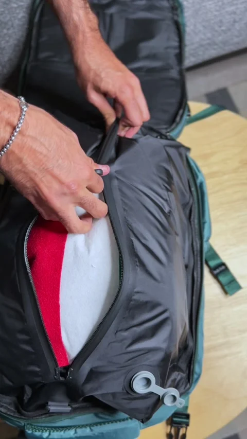 Person ziping Vacuum-Sealed Backpack – Smart Travel Gear Efficiency Concept Stock Footage 320329995