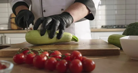 Personal chef prepares healthy salad, cuts zucchini on the cutting board Stock Footage 277954355