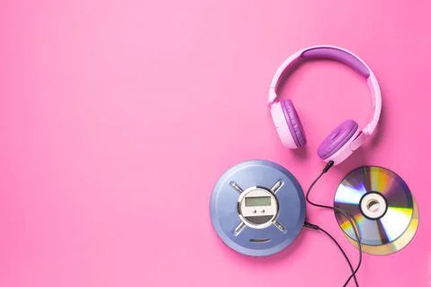 Personal compact portable CD player disks purple headphones on a pink background Stock Photos