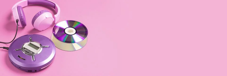 Personal compact portable CD player disks purple headphones on a pink background Stock Photos