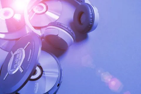Personal compact portable CD player disks headphones blue neon background, Top Stock Photos