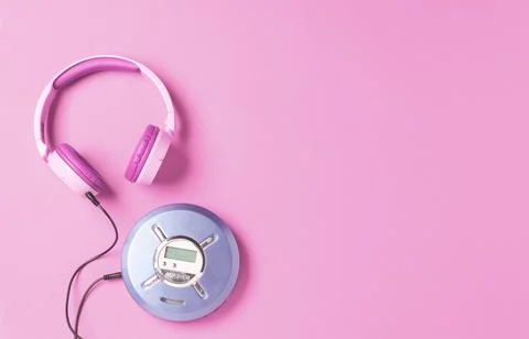 Personal compact portable CD player disks purple headphones on a pink background Stock Photos