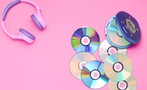 Personal compact portable CD player disks purple headphones on a pink background Stock Photos