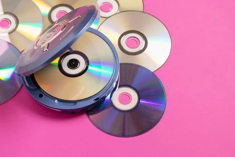 Personal compact portable CD player discs bright pink background. Top view Stock Photos