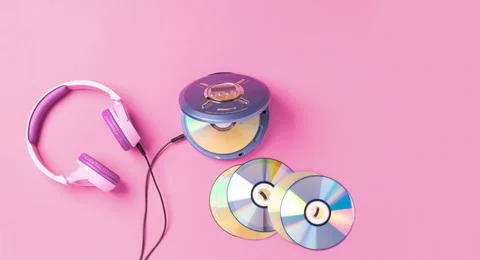 Personal compact portable CD player disks purple headphones on a pink background Stock Photos