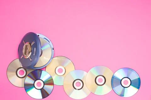 Personal compact portable CD player discs bright pink background. Top view Stock Photos