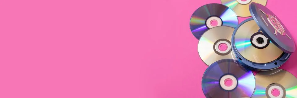 Personal compact portable CD player discs bright pink background. Top view Stock Photos