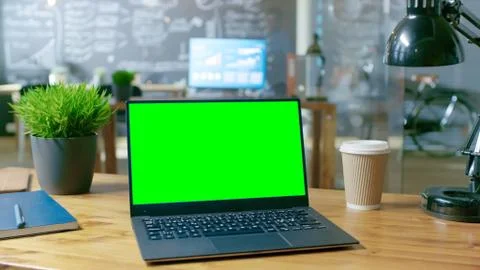 Personal Computer with Mock-up Green Screen Monitor Stands on the Office Desk 스톡 사진