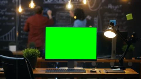Personal Computer with Mock-up Green Screen Monitor Stands on the Office Desk Stock Photos