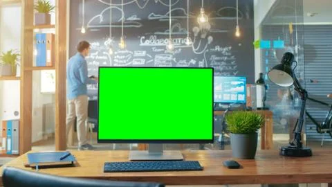 Personal Computer with Mock-up Green Screen Monitor Stands on the Office Desk Stock Photos