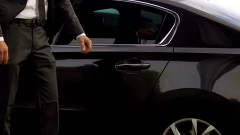Personal driver is opening the car door for his client Stock Footage