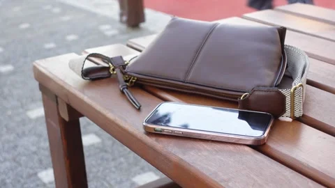 Personal items left on wooden table outdoors, lost smart phone concept Stock Footage 309167010