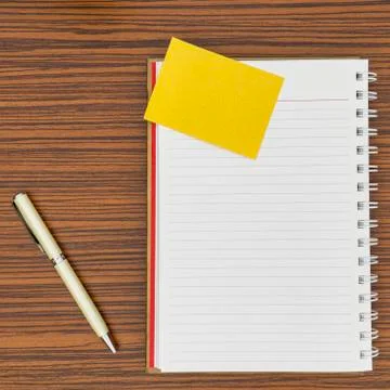 Personal notepad, yellow paper note and a pen on a zebra wood brown striped t Stock Photos