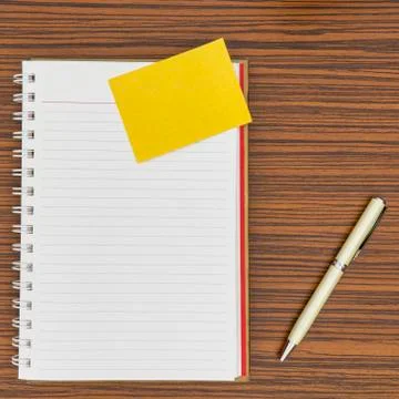 Personal notepad, yellow paper note and a pen on a zebra wood brown striped t Stock Photos