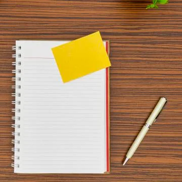 Personal notepad, yellow paper note and a pen on a zebra wood brown striped t Stock Photos