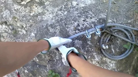 Personal perspective of climber on via ferrata, focus on using security ropes Video stock 87785402
