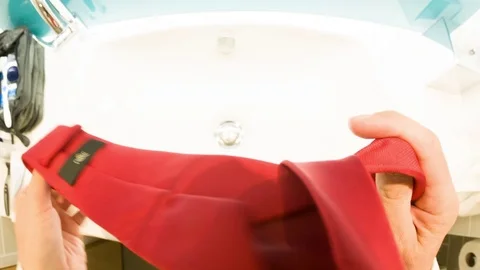 Personal perspective of a man putting on a tie in a hotel bathroom Stock Footage 79166715