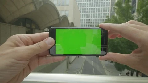 Personal perspective of a man using a Green-Screen smartphone outside the office Video stock 92520543