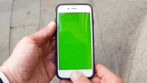 Personal perspective of a man using a smartphone with a green-screen Video stock 104071260