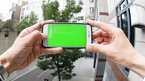 Personal perspective of a man using a smartphone with a green-screen Video stock 104117227