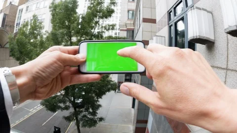 Personal perspective of a man using a smartphone with a green-screen Video stock 104117381
