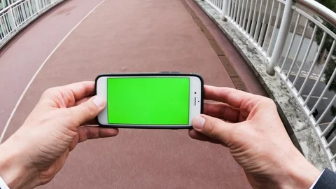 Personal perspective of a man using a smartphone with a green-screen Video stock 104117871