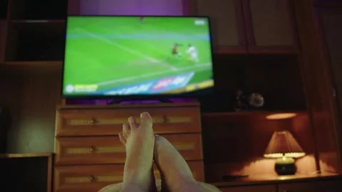 Personal perspective man watching soccer on smart TV in living room Stock Footage 314396236