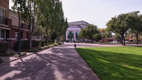 Personal perspective moving forward on a tree-lined sidewalk towards the main Vidéo 344951527