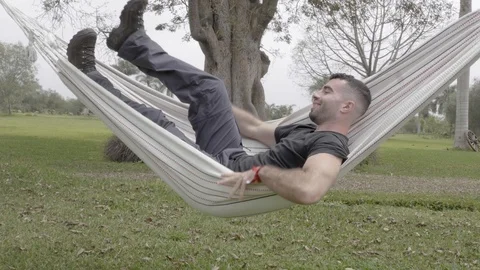 Personal perspective view of a man swinging in the hammock Stock Footage 125274828