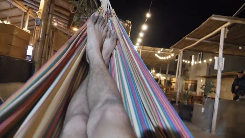 Personal perspective view of a man swinging in the hammock Stock Footage 125275347