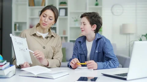 Personal private teacher tutor teach boy to do his homework help schoolboy with  Stock Footage 238632530