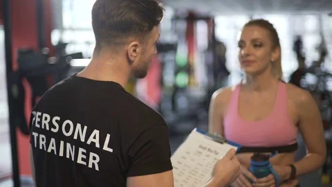 Personal trainer developing training program and explaining it to his client Stock Footage 75566493