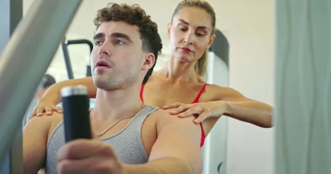 Personal Trainer Guides Client During Gym Workout Видео 323775848