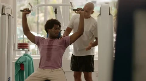 Personal trainer helping man working out in fitness gym Stock Footage 11144227