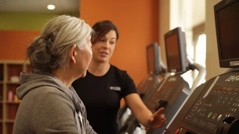 Personal trainer helping a student to use a treadmill. 스톡 동영상 88367749
