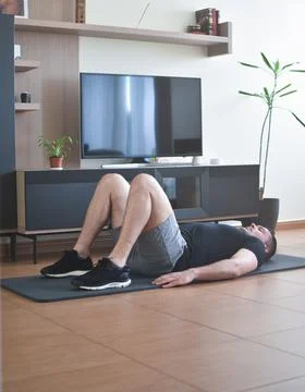 Personal trainer men doing exercises for a online lesson at home with a pc Stock Photos