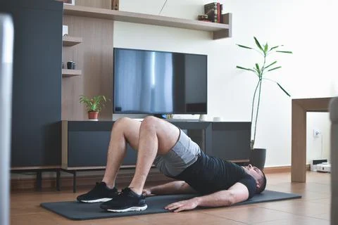 Personal trainer men doing exercises for a online lesson at home with a pc 스톡 사진