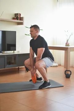 Personal trainer men doing squads exercises for a lesson at home 스톡 사진