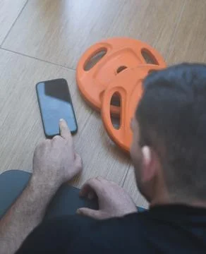 Personal trainer men using a phone for a lesson at home 스톡 사진