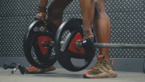 Personal trainer putting weights onto an Olympic sized bar in the gym Stock Footage 89577192