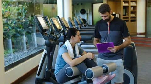 Personal trainer working with client in gym. Trainer man giving advises and 스톡 동영상 131030838