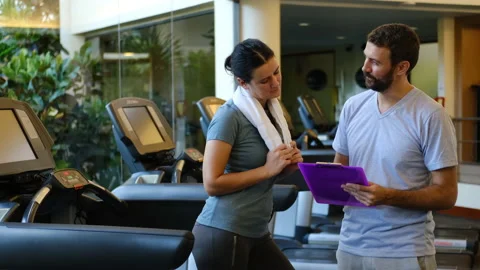 Personal trainer working with client in gym. Trainer man giving advises and 스톡 동영상 131036051