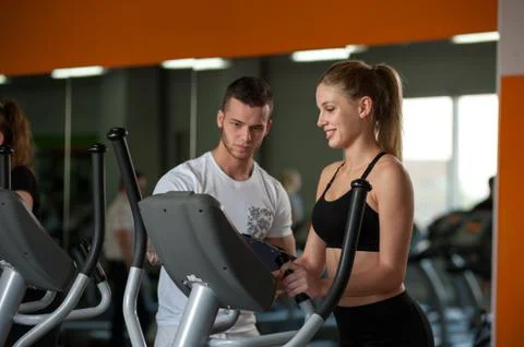 Personal trainer working with female client in gym Stock Photos