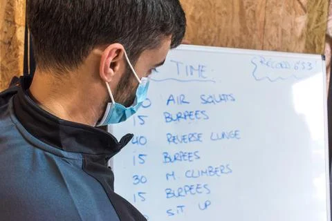 Personal trainer writing exercise chart on a whiteboard Stock Photos