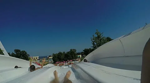 Personal view of man going down the waterslide in to the pool of water park Stock Footage 64977890
